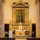 In marmo policromo, il tabernacolo � decorato da sei lunghi candelabri in argento e due putti dorati...